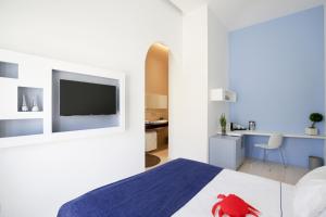 een slaapkamer met een bed en een tv aan de muur bij Al Castello Relais in Vieste
