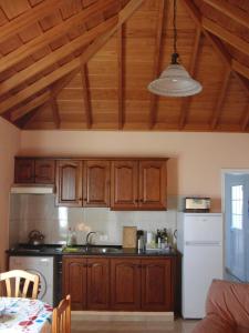 een keuken met houten kasten en een witte koelkast bij Finca Alexa in Arecida