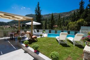 a patio with a table and chairs and a pool at Villa Amolena in Kariá