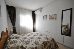 トレビエハにあるBergantin Fantastic sunny apartmentのベッドルーム1室(花柄のベッドカバー、鏡付)