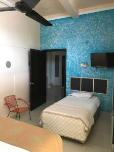 a bedroom with two beds and a blue wall at Hotel Central ParQ in Tonalá