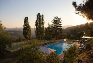 a view of a swimming pool with trees and mountains at Locanda di Praticino in Rufina