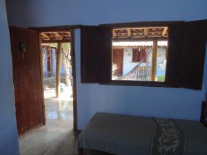 um quarto com uma janela e uma cama num quarto em Pousada Das Candeias em Carrancas