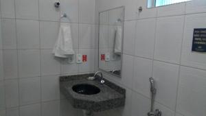 a bathroom with a sink and a mirror at Entre Rios Hotel in Picos