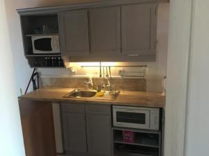 カルカンにあるClub Patara Villas 222の白いキャビネット、シンク、電子レンジ付きのキッチンが備わります。