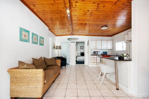 un soggiorno con un divano e un tavolo di Emabaleni Guest House PTY LTD a Port Elizabeth