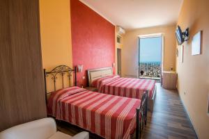 two beds in a room with red and yellow walls at Alla Chiazzetta Calabria in Amantea