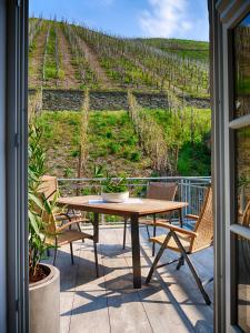 eine Terrasse mit einem Tisch und Stühlen sowie einem Weinberg in der Unterkunft Altes Lörscher Winzerhaus in Mehring