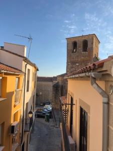 an alley in an old building with a tower at Casita del Abuelo Mayorga in Plasencia