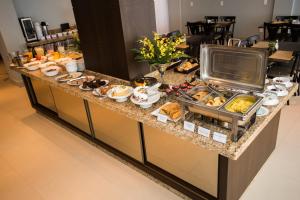 a breakfast buffet in a hotel room with food at SH Hotel Capinzal Premium in Capinzal