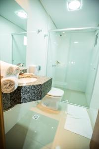 een badkamer met een glazen douche en een toilet bij Sense Hotel Premium in Capinzal