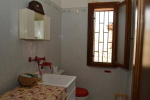 un bagno con lavandino, water e finestra di Villa Rosa - ai piedi dell'Etna a Brucoli Altre 41 foto