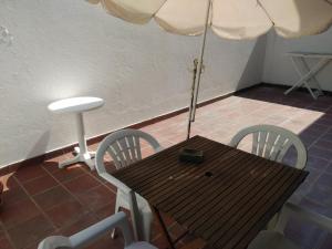 a table with an umbrella and a table and chairs at Apartamento Soares in Vila do Conde