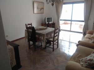 a dining room with a table and chairs and a television at Apartamento Soares in Vila do Conde