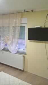 Habitación con ventana y cortina en Djurdja 2 Apartman en Arandjelovac