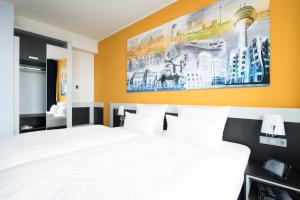 فندق كارات دوسلدورف سيتي في دوسلدورف: غرفة نوم بسرير ودهان على الحائط