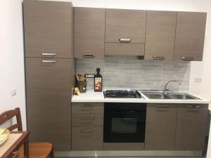 a kitchen with wooden cabinets and a stove top oven at B&B Relax in Agropoli