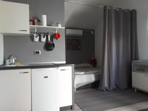 een keuken met witte kasten en een bed in een kamer bij Studio Apartman Splash in Pješčana Uvala