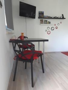 een zwarte tafel met een rode stoel in een kamer bij Studio Apartman Splash in Pješčana Uvala