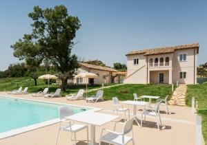 Villa con piscina con mesas y sillas en Villa Milli, en Notaresco