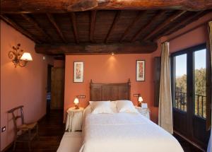 1 dormitorio con 1 cama grande y paredes de color naranja en Posada Real Ruralmusical, en Puerto de Béjar