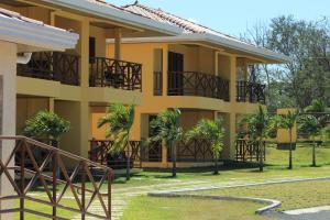 a yellow building with palm trees in front of it at Pocri Country Resort in Aguadulce