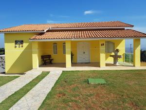 a yellow house with a yard in front of it at Recanto Dos Gansos in Pardinho