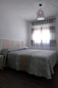 a bedroom with a bed and a window and a chandelier at El Ventanal de Almagro in Almagro