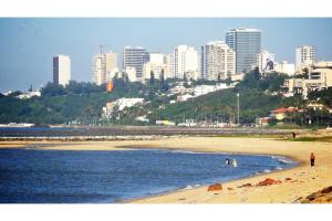 uma vista para uma praia com uma cidade ao fundo em Afrin Prestige Hotel em Maputo