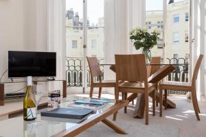 een woonkamer met een glazen tafel en een televisie bij Brighton Brunswick Apartments in Brighton & Hove