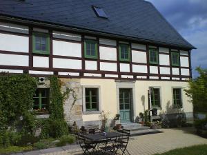 a building with a table and chairs in front of it at Lichtenhainer Hof in Lichtenhain