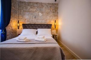 スプリトにあるBest4Stay Luxury Roomsのタオルが敷かれたベッドのある寝室