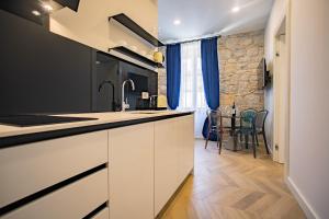 スプリトにあるBest4Stay Luxury Roomsの白いキャビネットとテーブルと椅子のあるキッチン