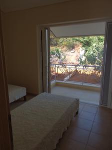 a bedroom with a bed and a view of a balcony at Maria House in Theologos
