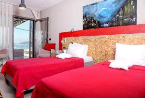 2 Betten in einem Hotelzimmer mit roter Bettwäsche in der Unterkunft Pitahaya Mutfak in Göltürkbükü