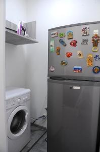 a refrigerator with magnets on it next to a washing machine at Sweet Home at Sololaki in Tbilisi City