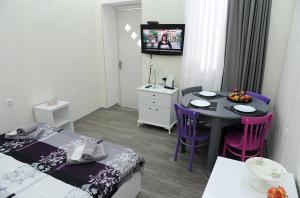 a room with two beds and a table and a tv at Sweet Home at Sololaki in Tbilisi City