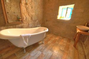 a bathroom with a bath tub and a sink at Belisırma Cave Pansiyon in Aksaray