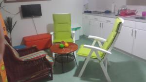 una cocina con 3 sillas y una mesa con fruta. en Alifra Apartment, en Lagun