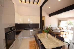 a kitchen and living room with a table and a couch at Apartmani Katarina in Herceg-Novi