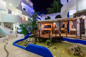 a pool in the middle of a building with a house at Matan Kaan by GuruHotel in Mahahual