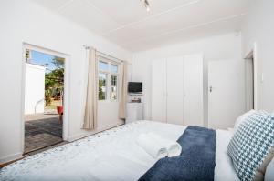 una camera da letto bianca con un letto grande e una finestra di Emabaleni Guest House PTY LTD a Port Elizabeth