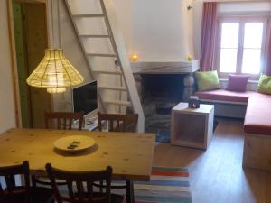 ein Wohnzimmer mit einem Esstisch und einer Treppe in der Unterkunft Ches'Arsa in La Punt-Chamues-ch