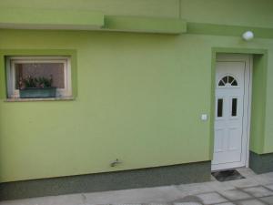a green wall with a white door and a window at Apartma Juha - in Breg pri Borovnici