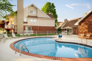 a swimming pool in front of a house at Hawthorn Suites by Wyndham Tinton Falls in Tinton Falls