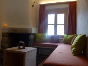 ein Wohnzimmer mit einem Sofa und einem Fenster in der Unterkunft Ches'Arsa in La Punt-Chamues-ch