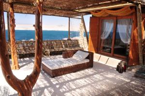 a couch on a porch with a view of the ocean at Hospedaje Boutique Ckamur in Caldera
