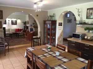 a kitchen and dining room with a table and a living room at Pensjonat Pod Orzechami in Magdalenka