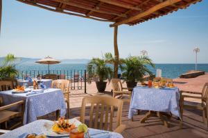 a restaurant with tables and chairs and the ocean at Vamar Vallarta Marina & Beach Resort in Puerto Vallarta