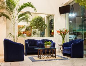 a lobby with blue chairs and a coffee table at Plaza Inn Express in Tapachula
